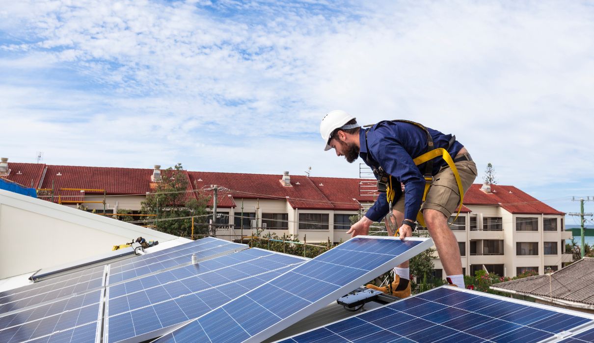 Solar installer fitting panels on a residential roof