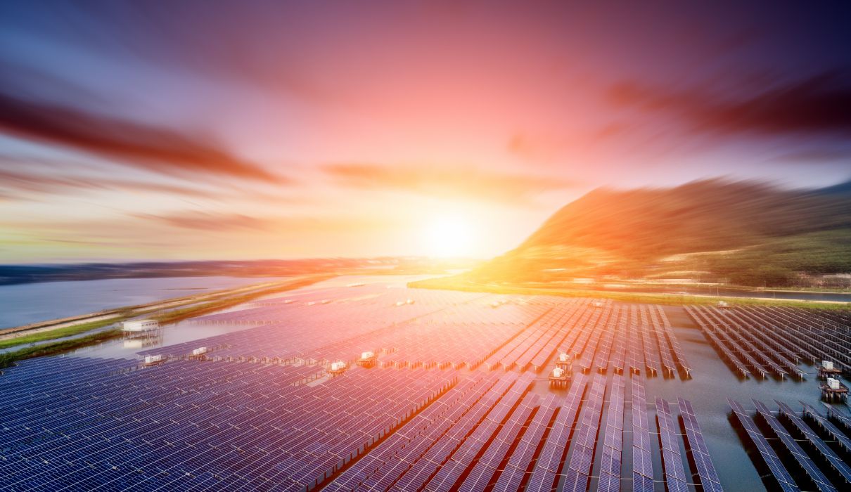 A miniature house with solar panels held in an open hand — advisory consultation